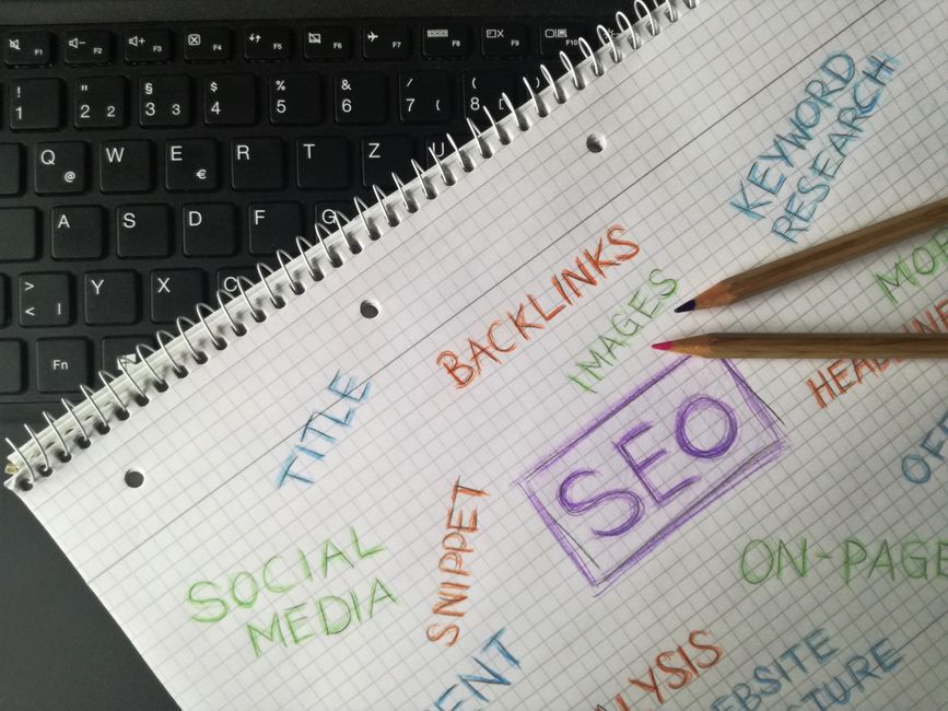 Carnet de notes avec des mots-clés SEO posé sur un bureau